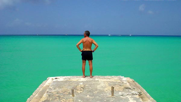 Photo of Paul Bardo in front of the open sea with his arms on his hips.